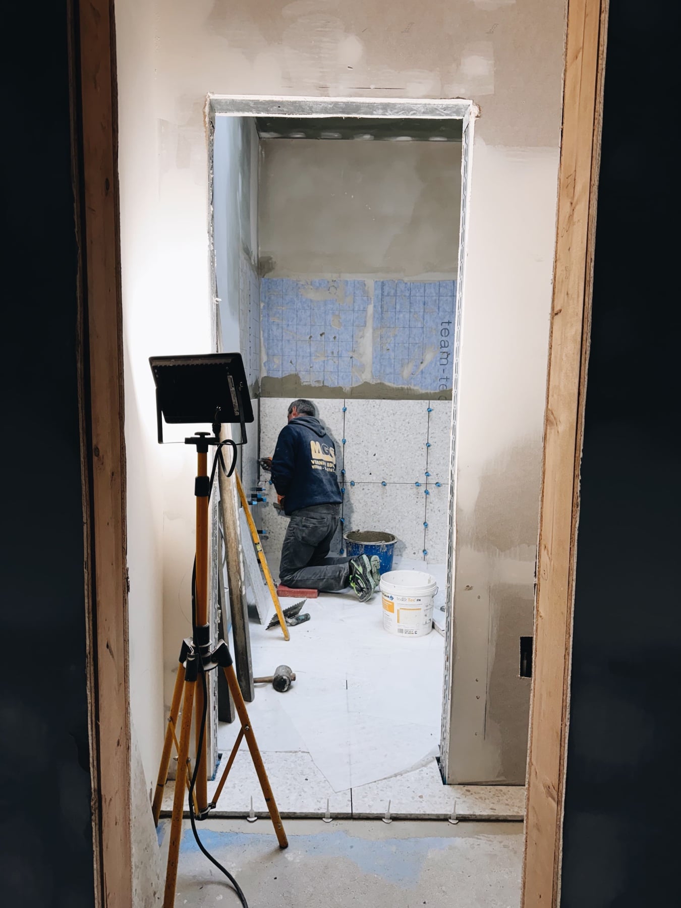 A builder with a work light on the ground floor