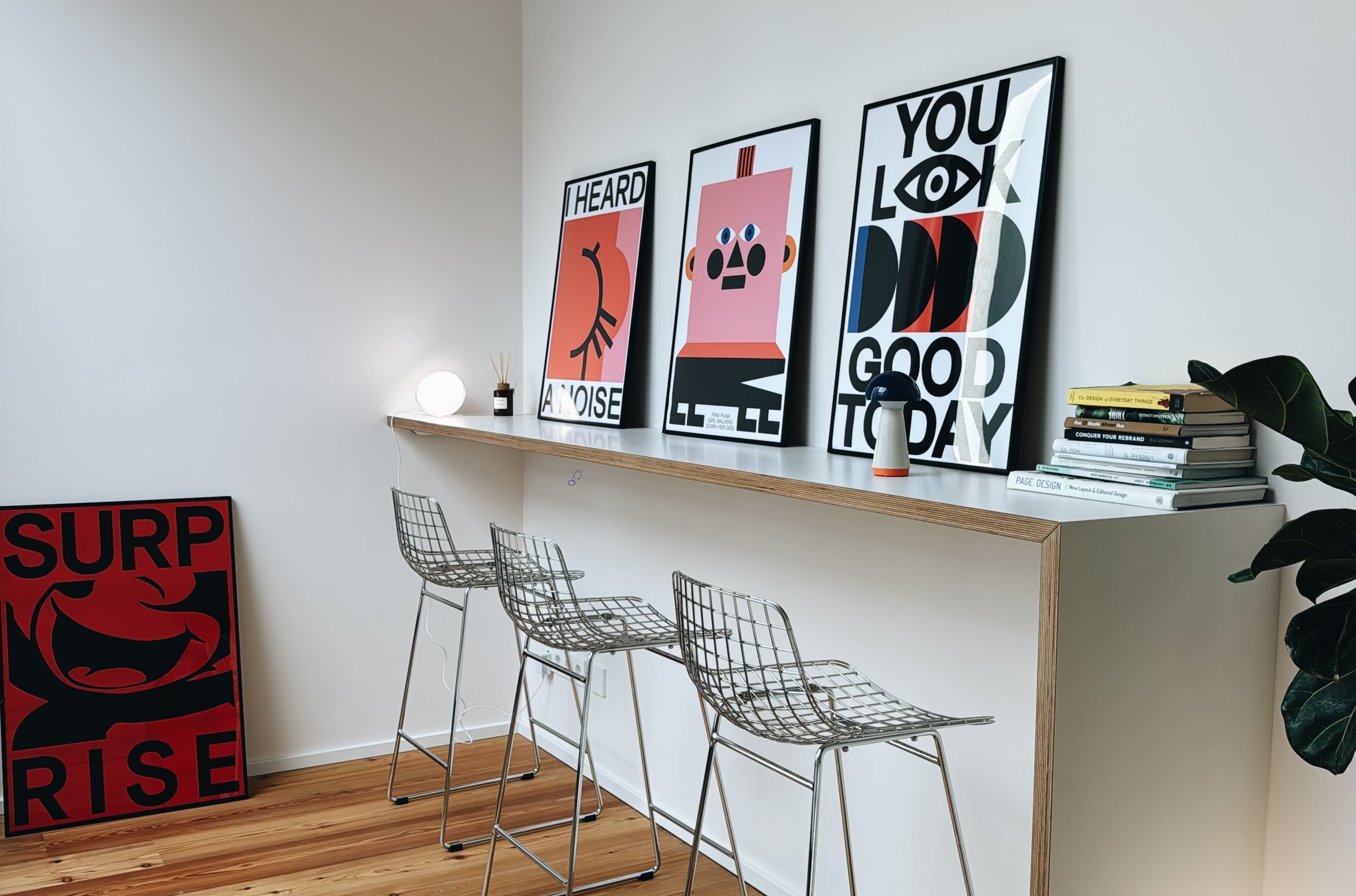Die Bar im Obergeschoss: drei Poster, drei Barhocker, ein Stapel Bücher