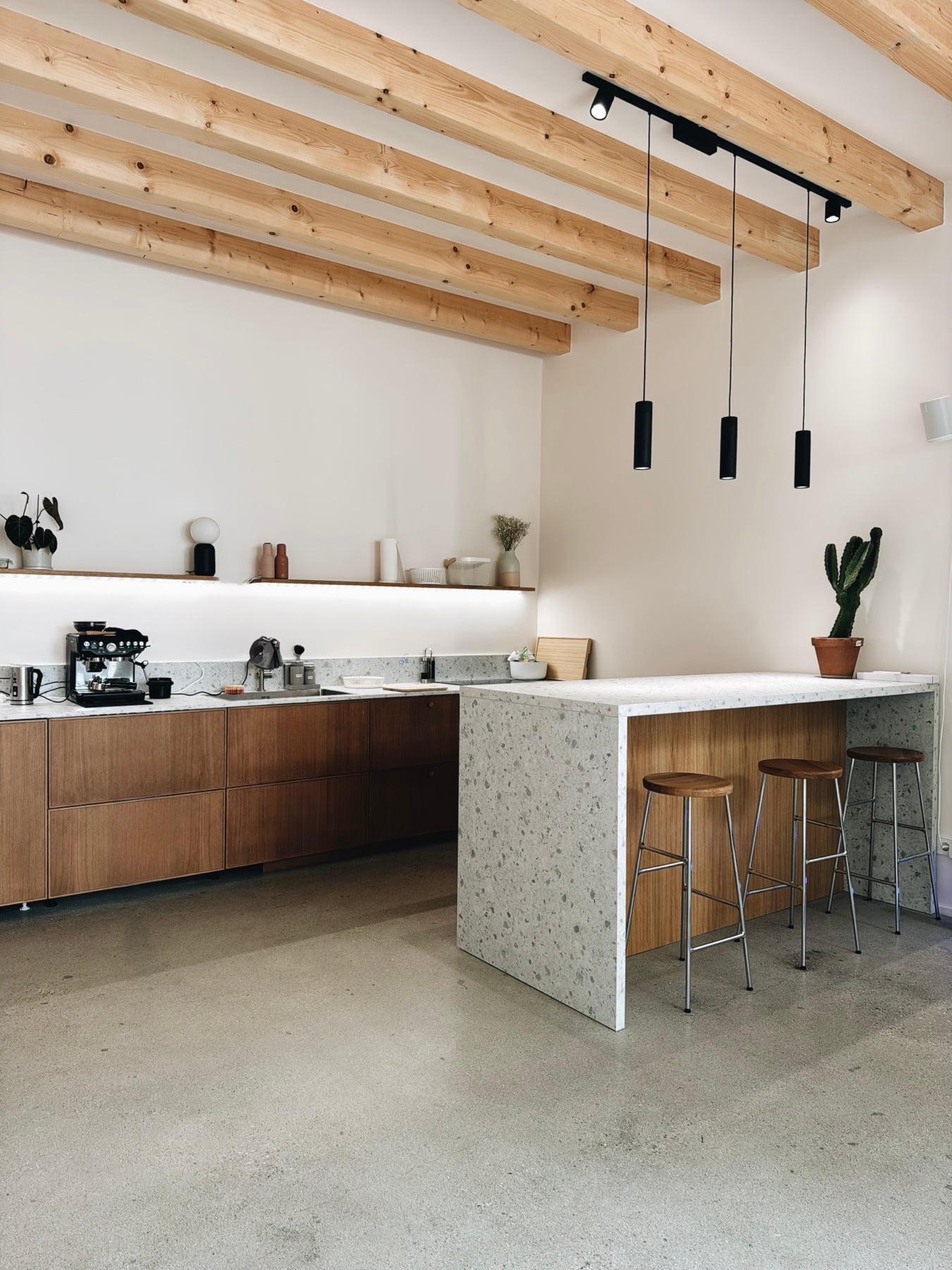 Die Küche: Terrazzo-Theke, Holzfronten, Siebträger, Barhocker