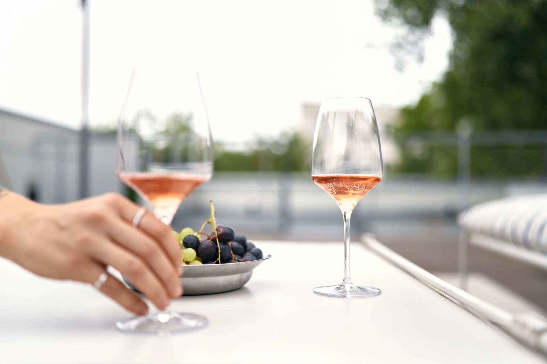Zwei Gläser Rosé und Trauben auf der Dachterrasse