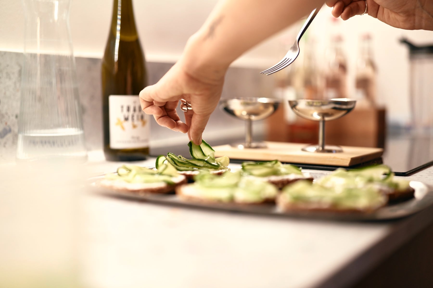 Hands garnishing canapés on the kitchen counter