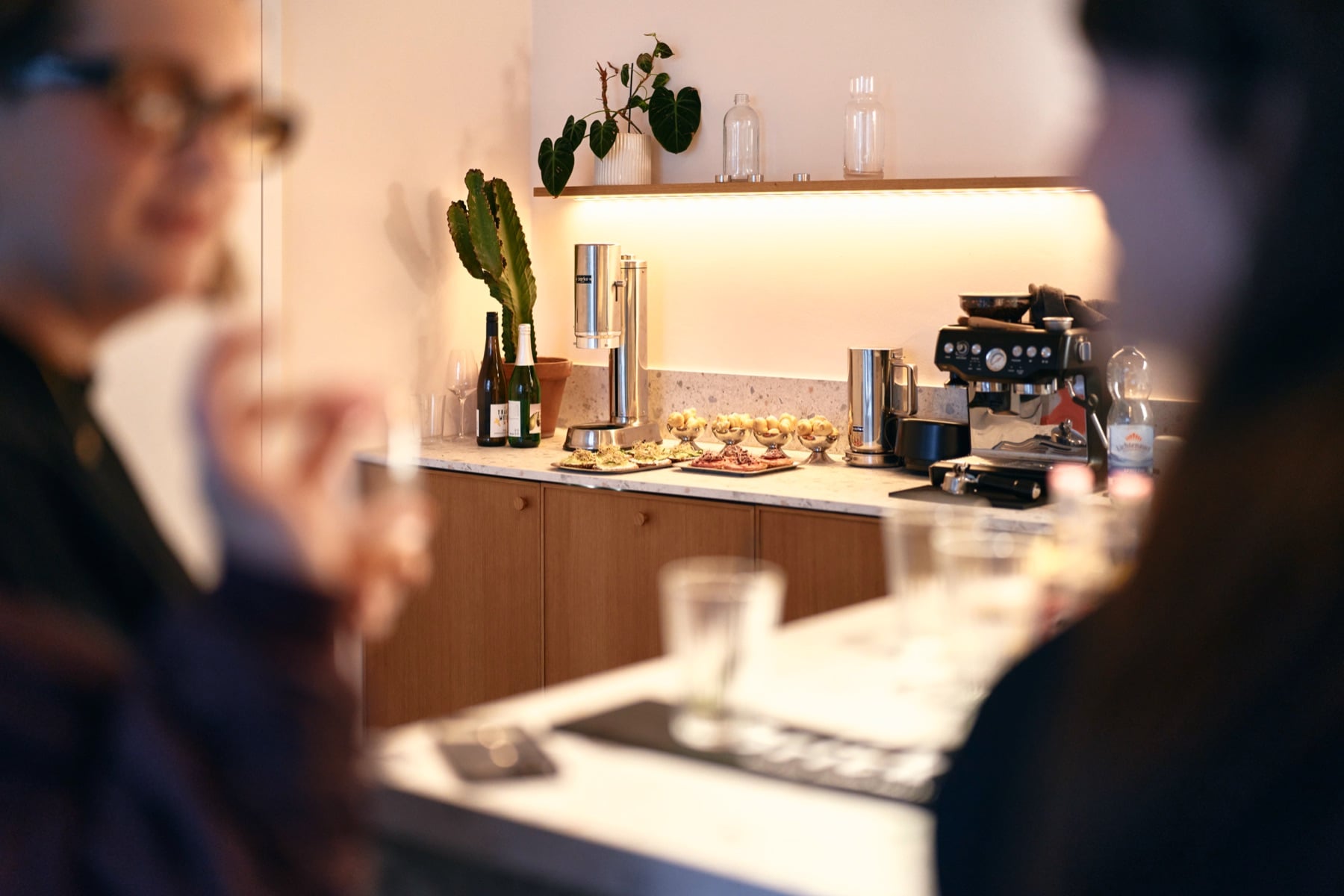 Gäste an der Küchentheke mit Wein und Canapés