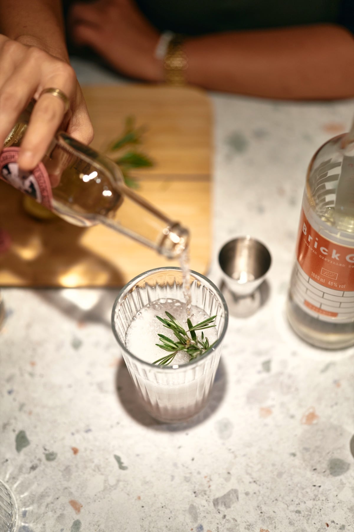 Ein Drink wird über Rosmarin aufgegossen