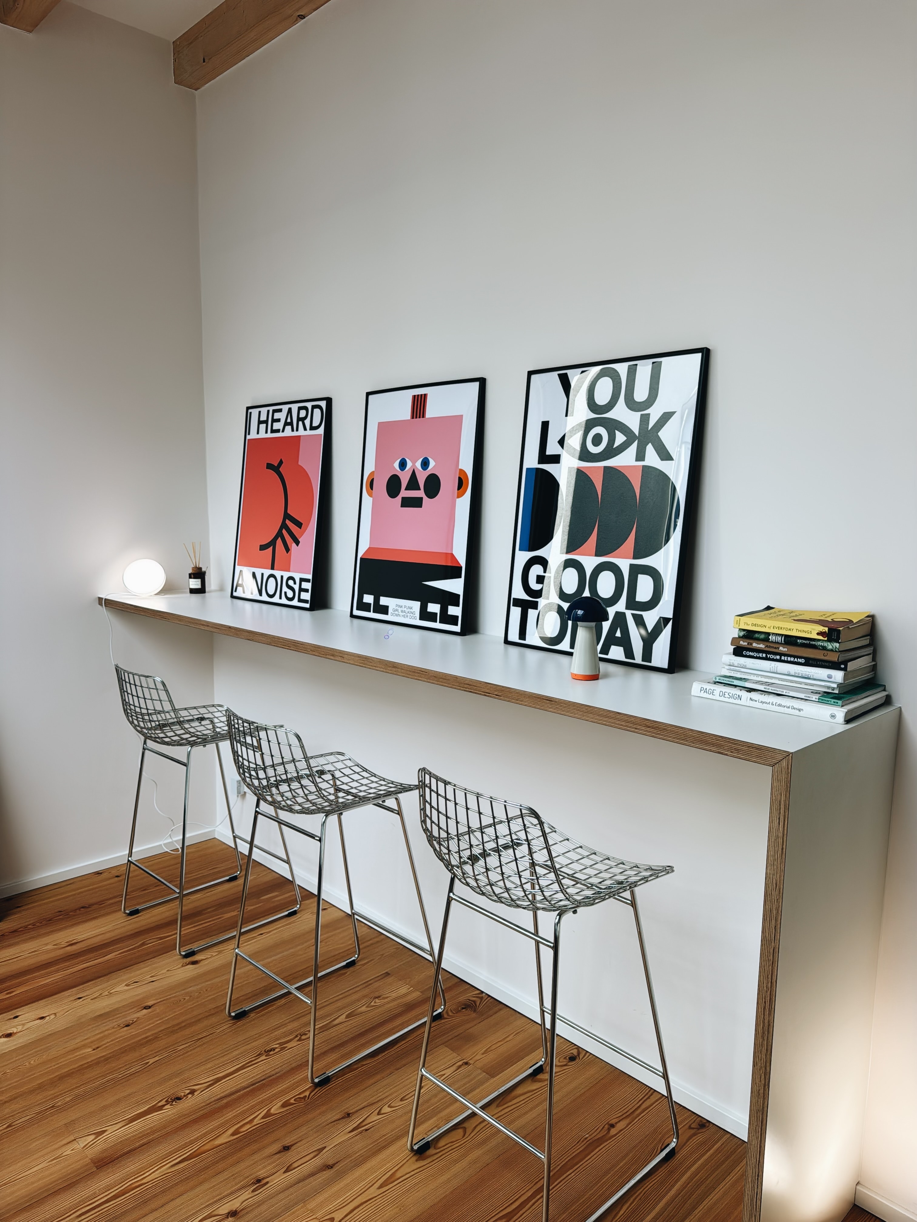 The bar on the upper floor: three posters, three bar stools, a stack of books